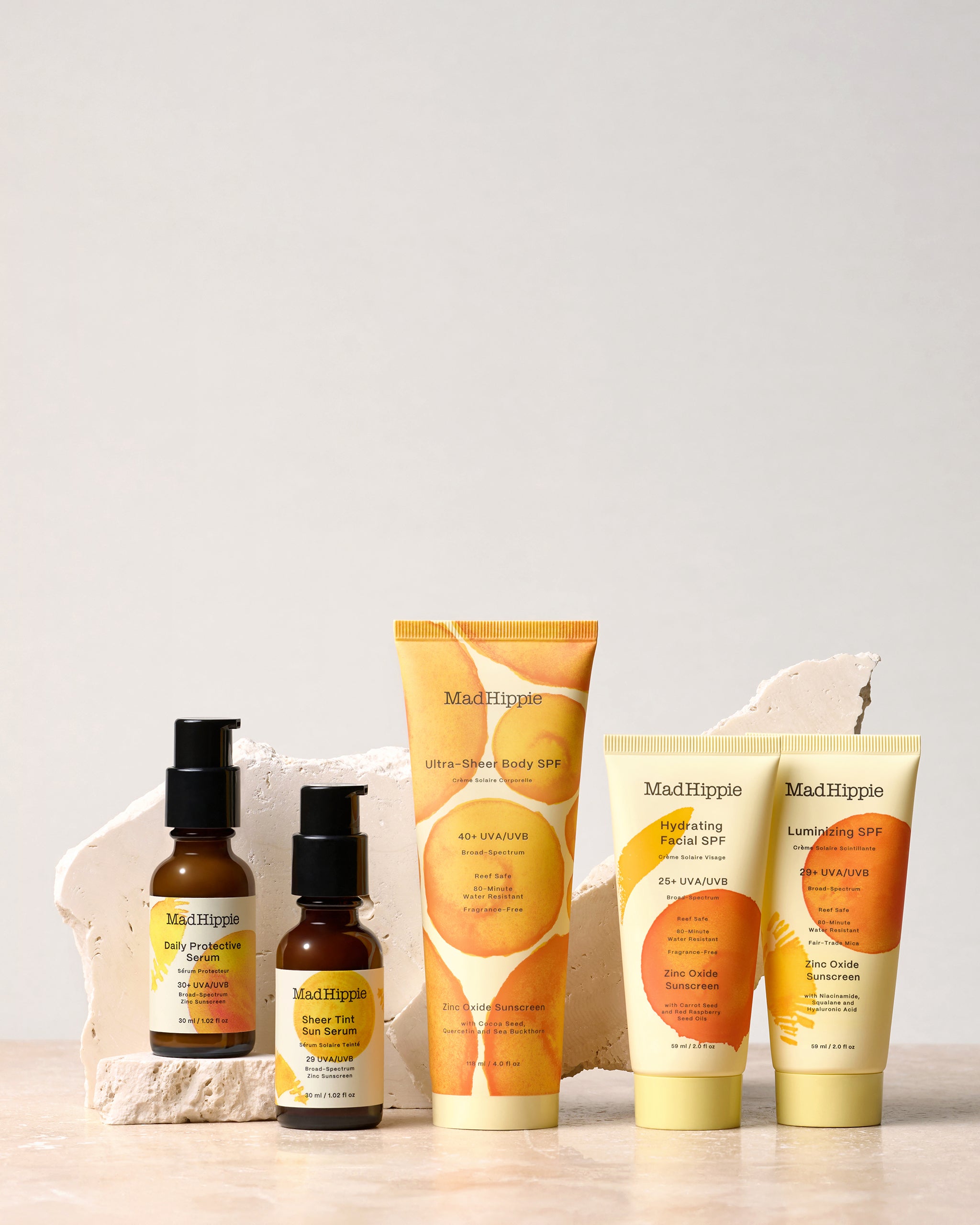 Multiple sunscreen bottles and tubes on grey background